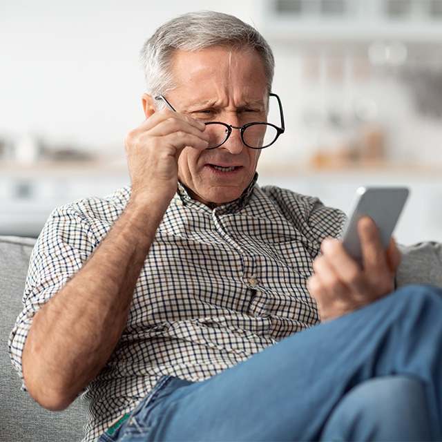 man squining through glasses
